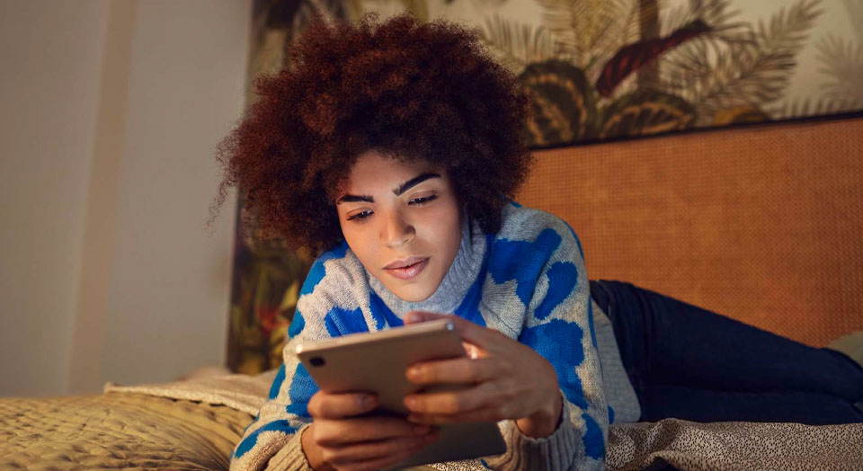 Mann mit buntem Hemd schaut auf sein Smartphone